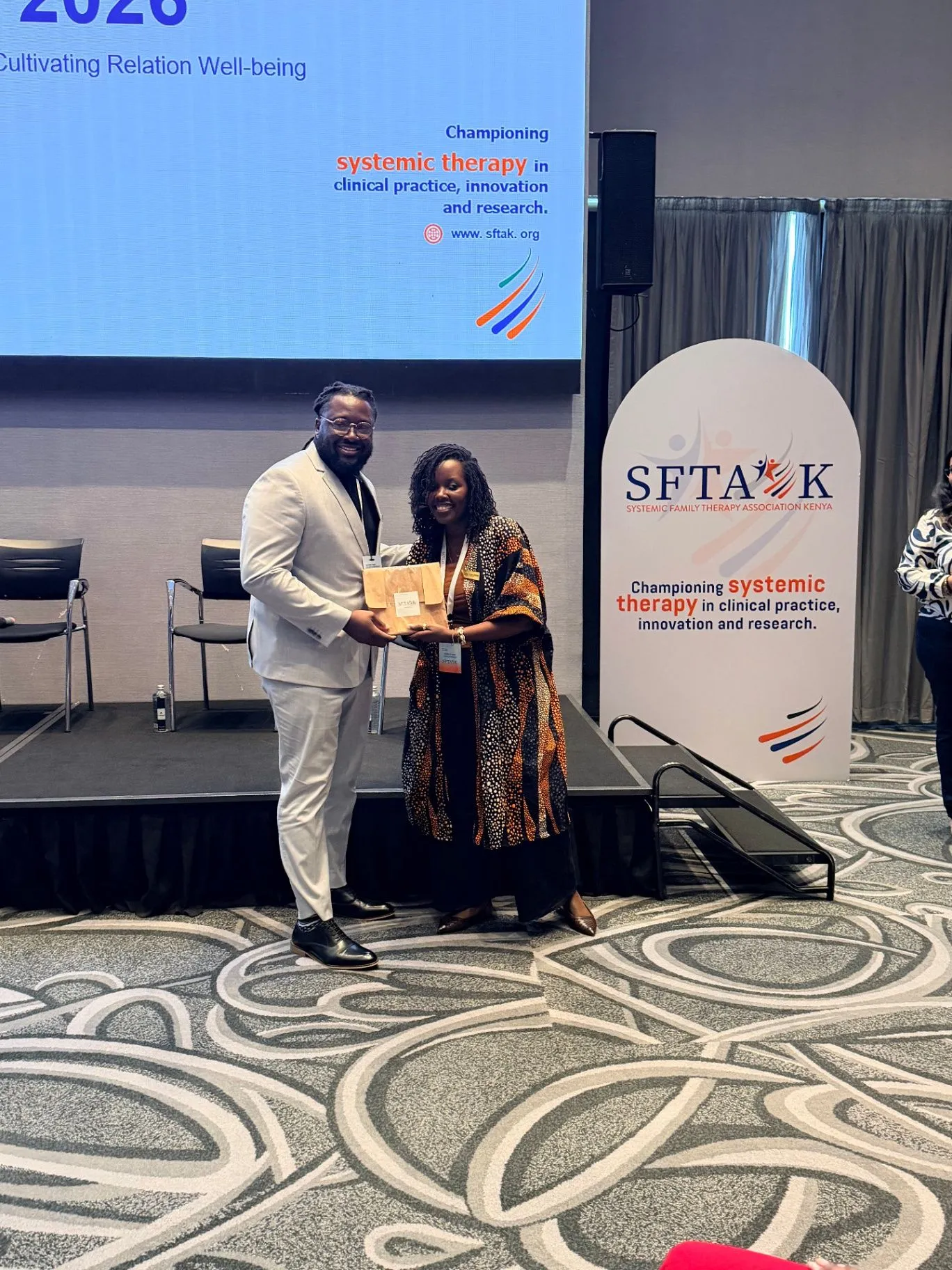Maurice presenting an award beside a colleague at a systemic family therapy conference in Kenya