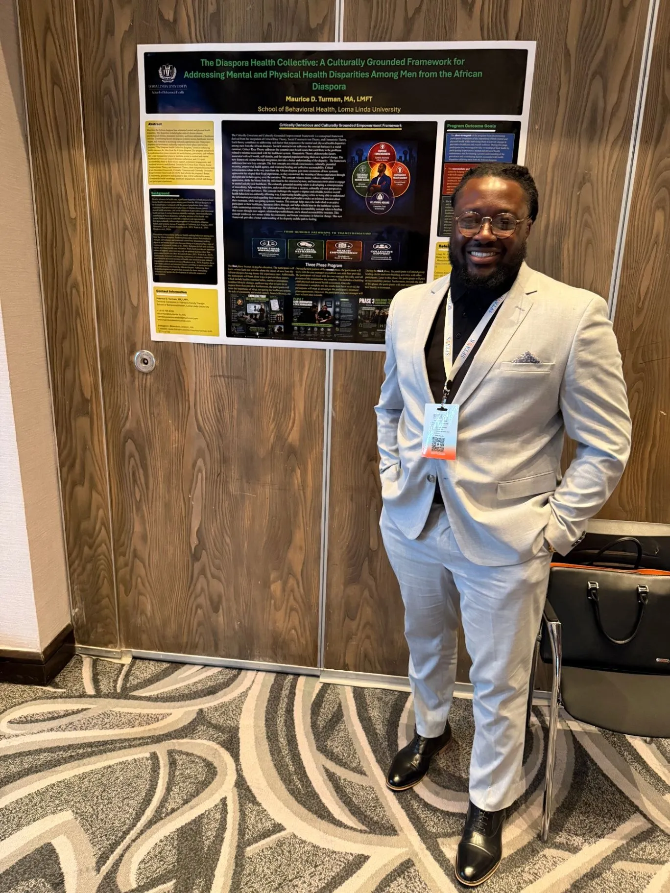 Maurice standing beside a research poster at a professional conference